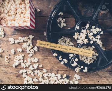 Cinema concept of vintage film reel with popcorn and movie tickets