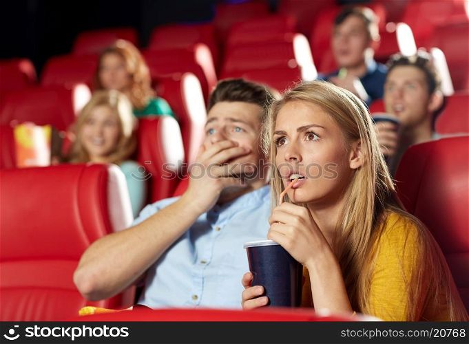 cinema, entertainment and people concept - couple drinking soda and watching horror, drama or thriller movie in theater