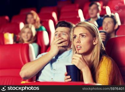 cinema, entertainment and people concept - couple drinking soda and watching horror, drama or thriller movie in theater