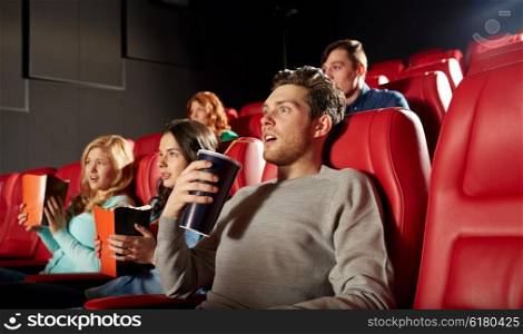 cinema, entertainment and people concept - friends with popcorn and soda watching horror or thriller movie in theater