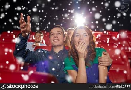 cinema, entertainment and people concept - happy couple watching movie in theater over snowflakes