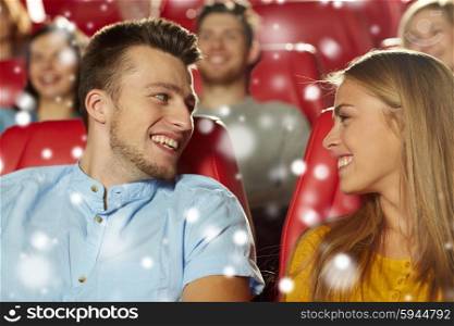 cinema, entertainment and people concept - happy friends or couple watching movie and talking in theater with snowflakes