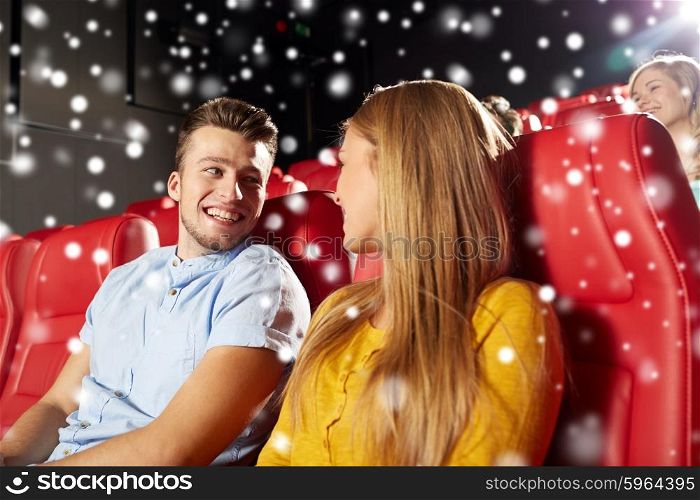 cinema, entertainment and people concept - happy friends or couple watching movie and talking in theater over snowflakes
