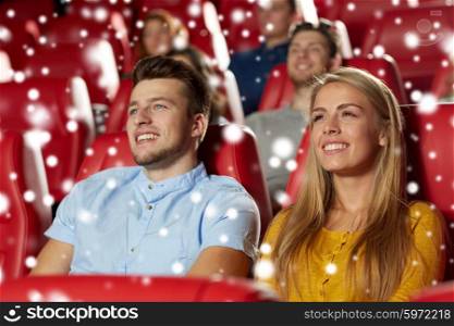 cinema, entertainment and people concept - happy friends or couple watching movie in theater over snowflakes