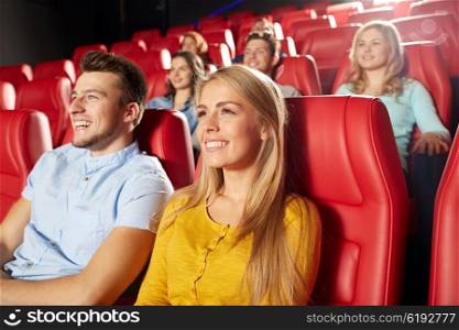 cinema, entertainment and people concept - happy friends watching comedy movie in theater