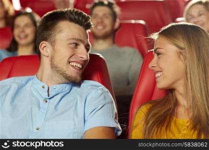 cinema, entertainment and people concept - happy friends watching movie and talking in theater
