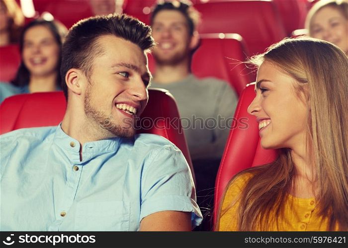 cinema, entertainment and people concept - happy friends watching movie and talking in theater