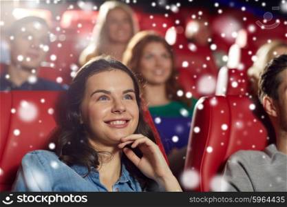 cinema, entertainment and people concept - happy woman watching comedy movie in theater over snowflakes