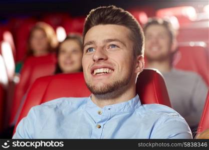 cinema, entertainment and people concept - happy young man watching comedy movie in theater