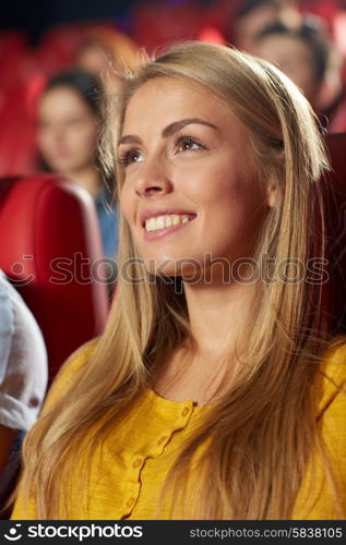 cinema, entertainment and people concept - happy young woman watching comedy movie in theater