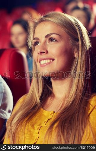 cinema, entertainment and people concept - happy young woman watching comedy movie in theater