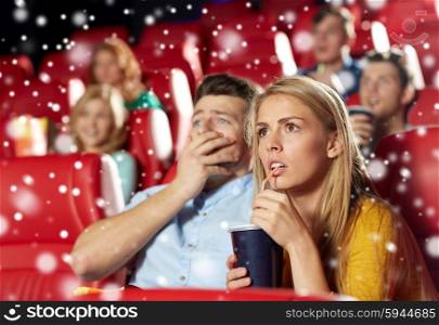 cinema, entertainment and people concept - terrified couple drinking soda and watching horror, drama or thriller movie in theater with snowflakes