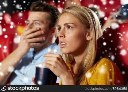 cinema, entertainment and people concept - terrified couple drinking soda and watching horror, drama or thriller movie in theater