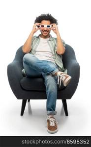cinema, leisure and entertainment concept - happy smiling young man in 3d glasses watching movie sitting in chair over white background. man in 3d glasses watching movie sitting in chair