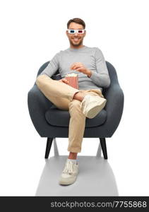 cinema, people and leisure concept - happy smiling man 3d glasses eating popcorn sitting in chair over white background. man in 3d glasses eating popcorn sitting in chair