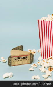 cinema tickets with popcorns against blue backdrop