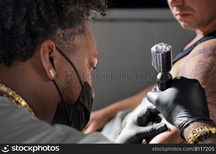 Cinematic shot of a Tattoo artist creating Body art at the tattoo studio. High quality photography. Cinematic shot of a Tattoo artist creating Body art at the tattoo studio