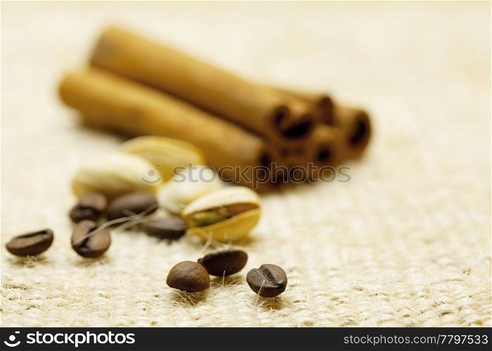 cinnamon , coffee beans and pistachios on linen fabric