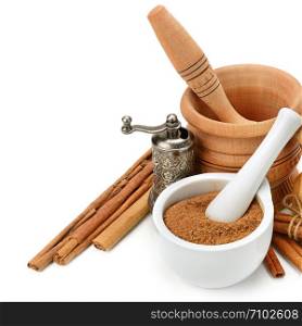 Cinnamon, mortar and pestle, hand grinder isolated on white background. Healthy food. Free space for text.