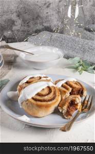 Cinnamon rolls or cinnabon with icing for Christmas. Homemade traditional winter festive dessert buns. Pastry food for breakfast on white background