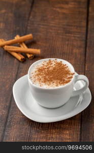 Cinnamon sprinkled salep in a white cup on wooden table