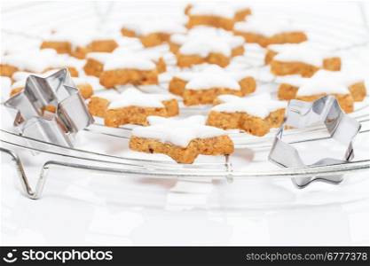 cinnamon stars on a cooling grid. many christmas cinnamon stars on a cooling grid with metal molds