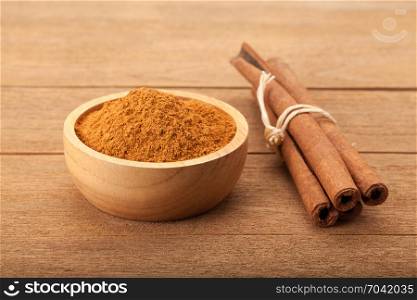 Cinnamon stick and cinnamon powder on wood background