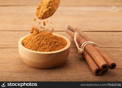 Cinnamon stick and cinnamon powder on wood background