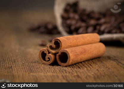 cinnamon sticks and coffee on hessian canvas with wooden background