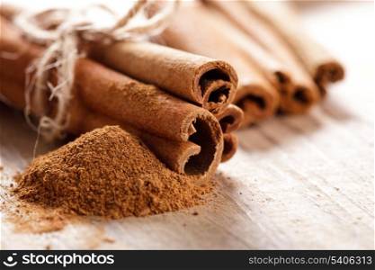 Cinnamon sticks and meal close up on wooden table