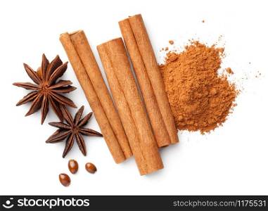 Cinnamon sticks and powder pile, anise stars and seeds isolated on white background. Flat lay. Top view