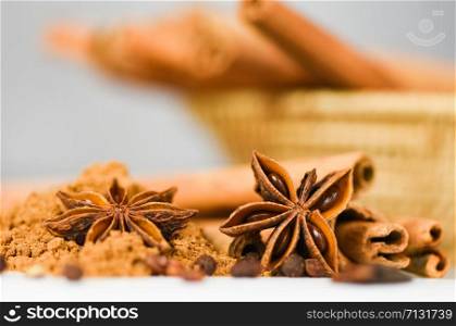 Cinnamon sticks and Star Anise on cinnamon powder herbs and spices on white background