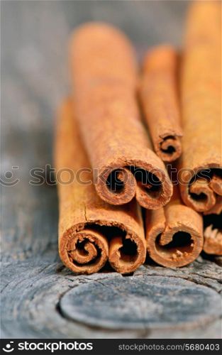 Cinnamon sticks in bucket on old wooden background