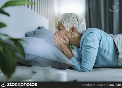 Circadian rhythm sleep disorder. Worried mature woman in bed staying awake late at night