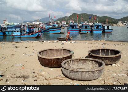 Circle boats on the beach and fishing vessels in Nha Trang, Vietnam