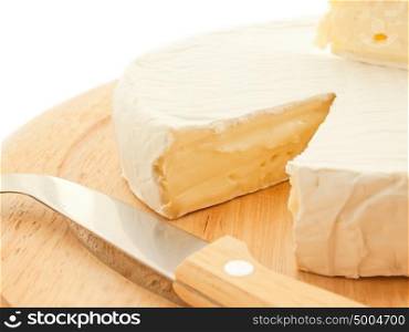 Circle Brie cheese on wooden desk with knife isolated
