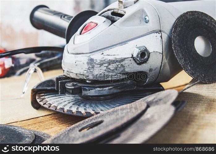 circles for the angle grinder are on wooden boards near the grinder. The concept of tools and repair work.. circles for the angle grinder are on wooden boards near the grinder.