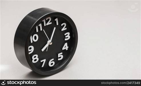 circular black alarm clock against gray background