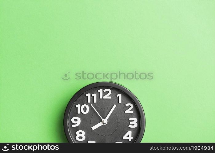 circular black clock green wall backdrop. Beautiful photo. circular black clock green wall backdrop