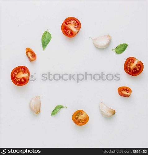 circular frame made with cherry tomatoes basil garlic cloves white background. Resolution and high quality beautiful photo. circular frame made with cherry tomatoes basil garlic cloves white background. High quality beautiful photo concept