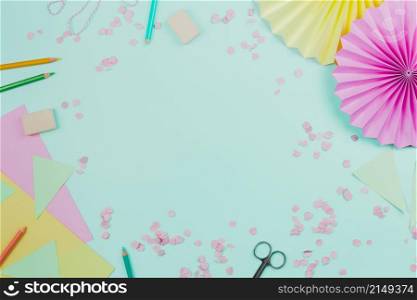 circular paper fan with confetti colored pencils teal background