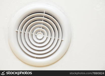 circular plastic air vent in white wall ventilation grille