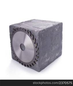 Circular saw blade and concrete cube or cement block isolated on white background