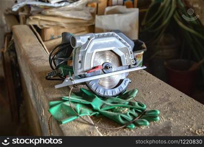 Circular saw for cutting and gloves on the table