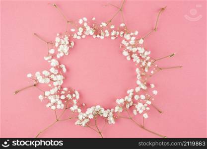 circular shape made from baby s breath against peach background