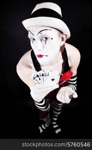 Circus clown with playing cards isolated on black background