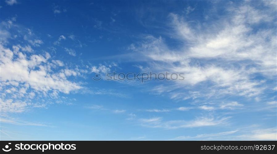 Cirrus clouds against the dark blue sky. Heavenly background.