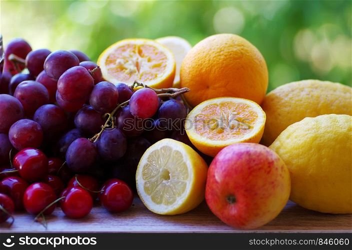 citric fruits, cherrys and grapes on table