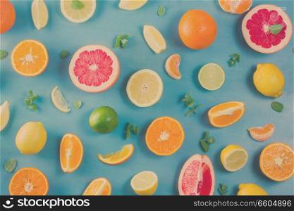 citrus food pattern on blue background - assorted citrus fruits with mint leaves, retro toned. citrus pattern on blue