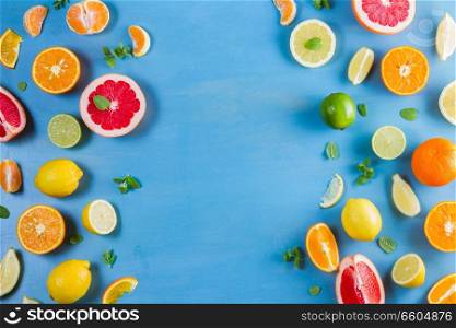 citrus food top view flat lay borders pattern on blue background - assorted citrus fruits with mint leaves. citrus pattern on blue